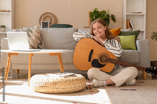 Young woman playing guitar ...