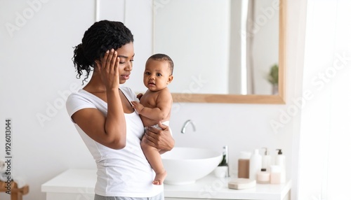 Mother holding her baby in a bathroom