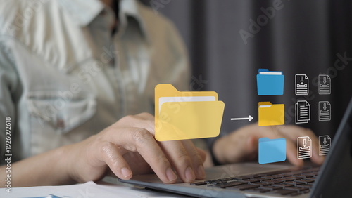Digital file management concept with professional organizing folders on laptop and virtual document icons. Cloud storage, data organization, file transfer, backup system, document management workflow.