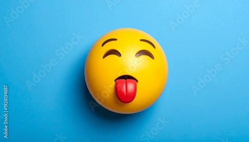 Smiling emoji with tongue on blue background.