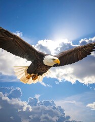 A bald eagle flies in a blue sky with clouds