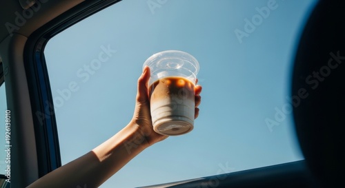 Hand Holding Iced Coffee Out Car Window
