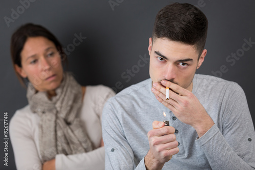 Fotografía young man smoking cigarette and get caught by his mother