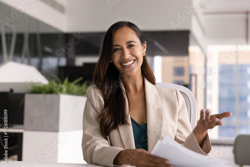 Businesswoman, bank advisor or secretary conduct meeting with colleagues or clients using videocall app seated at desk, holds papers, looks at camera. Virtual meeting, digital, business communication Free Download Businesswoman, bank advisor or secretary conduct meeting with colleagues or clients using videocall app seated at desk, holds papers, looks at camera. Virtual meeting, digital, business communication - GFXLoad