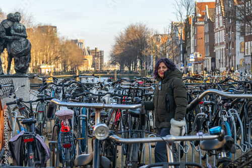 Photography Mature traveler enjoying a city break in amsterdam, surrounded by numerous bicyc
