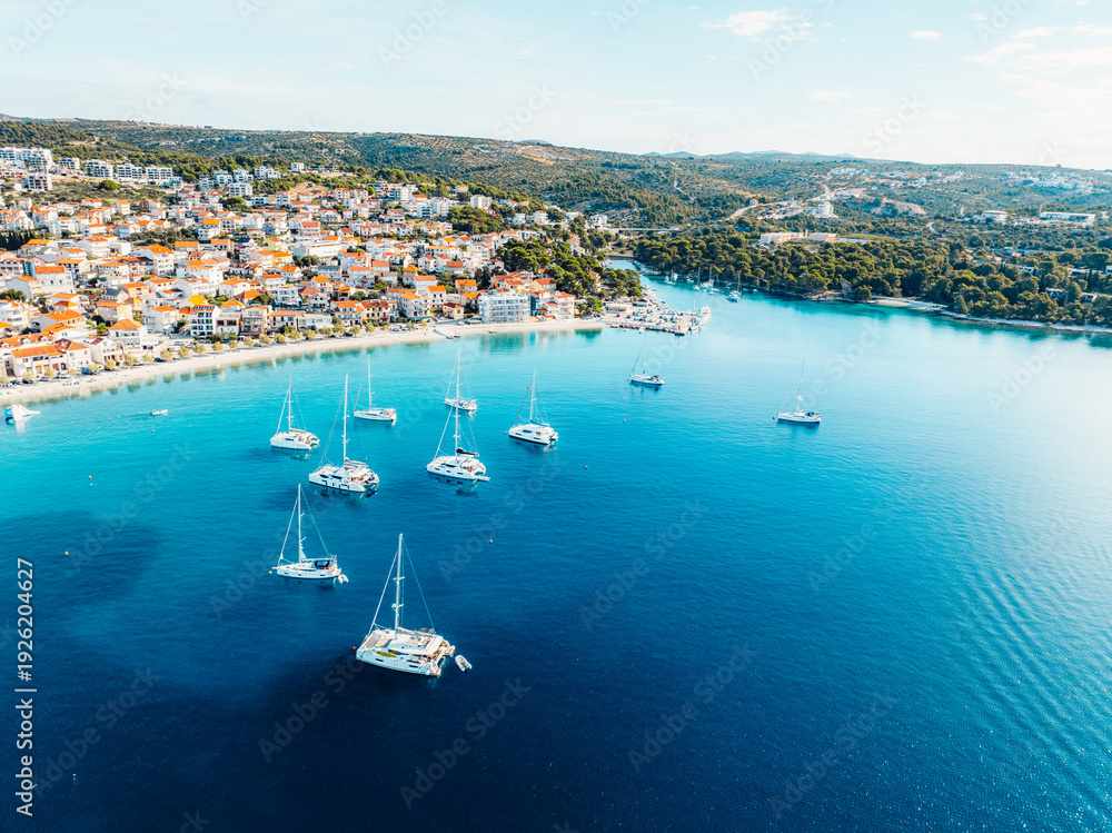 Obraz premium Aerial view of the historic town of Primosten on a peninsula, surrounded by crystal clear turquoise Adriatic sea, Dalmatia, Croatia.