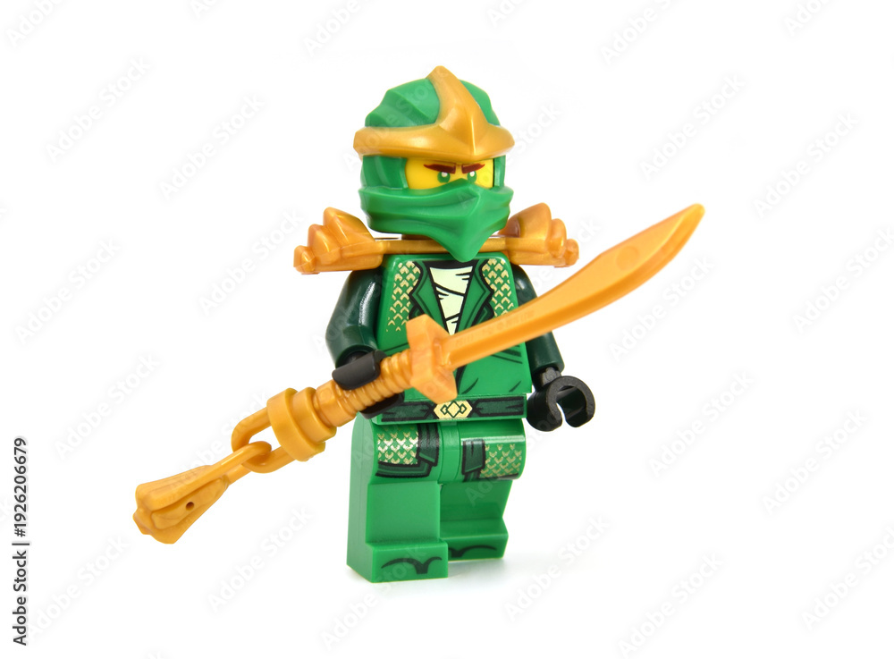Fototapeta premium Editorial illustrative image of lego minifigure of green ninja Lloyd with golden blade or sword weapon isolated on white. Jubilee 15 years of lego Ninjago.