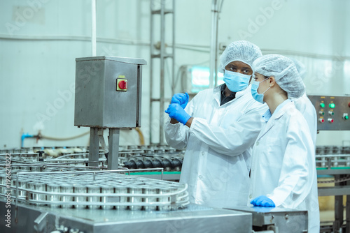 фотографія Food factory quality assurance team reviews production batch and analyzes packaging details in controlled manufacturing environment