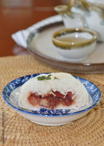 Steamed buns with barbecued pork filling with hot Chinese tea cup