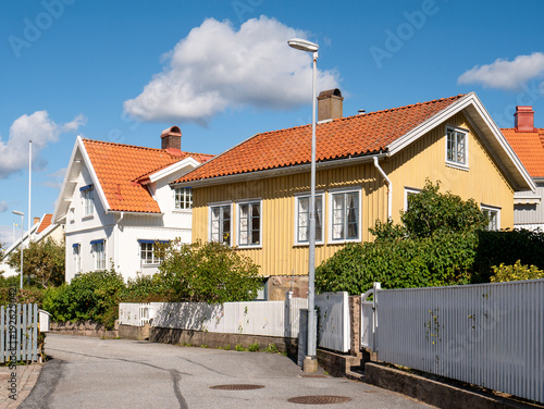 Wooden houses along Stöbergsliden in Grebbestad, Bohuslän, west coast Sweden, with residential streetscene, fences and tiled roofs in coastal town setting