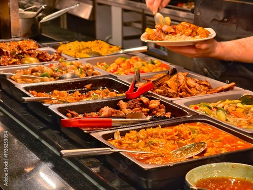 Chef serves delicious hot food selection from a fully stocked Asian buffet line with various options.