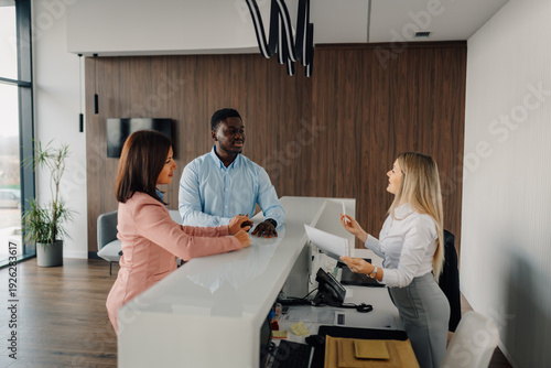 Fotografie Diverse guests checking in at reception desk