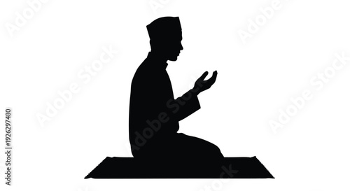 A kneeling man in traditional attire shown in stark silhouette