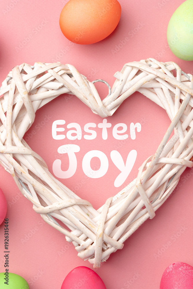 Fototapeta premium Easter joy is celebrated with colorful eggs and a heart-shaped decoration on a pink background