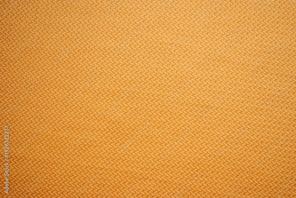 Fototapeta premium Primer plano de textura de tela de camisa en color mostaza con patrón de espiga.