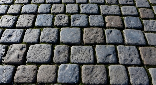Close up of weathered cobblestone pavement with dark gray rectangular stones