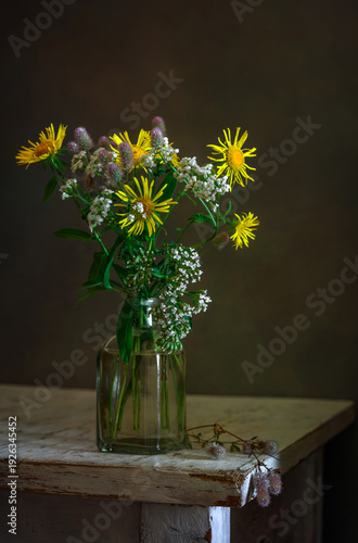 A small bouquet of meadow flowers on a dark background.