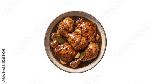 Filipino chicken adobo dish with garlic and bay leaves in a bowl, top view