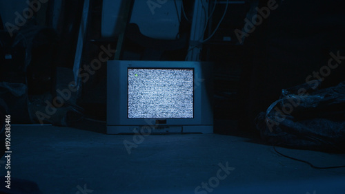 Bild auf Leinwand A vintage CRT television displaying static noise, set against a dark and moody background, evoking a retro atmosphere