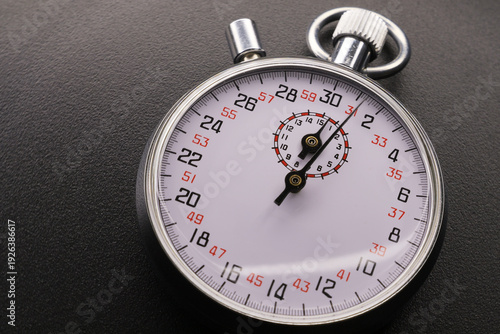 Analog stopwatch on black background.