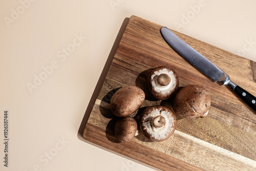Fresh Brown Mushrooms on a Wooden Cutting Board with a Knife
