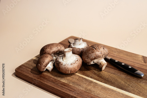 Fresh Brown Mushrooms on a Wooden Cutting Board with a Knife