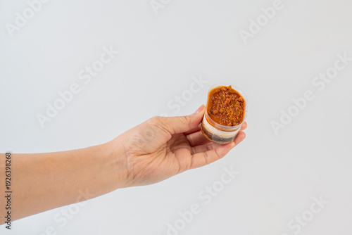 Wallpaper Mural Three-layered brownie cake topped with crunchy topping in a clear cup and hand. Torontodigital.ca