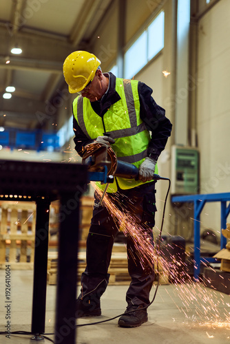 Industrial Worker Grinding Metal in Workshop With Safety Vest and Hard Hat Creating Sparks