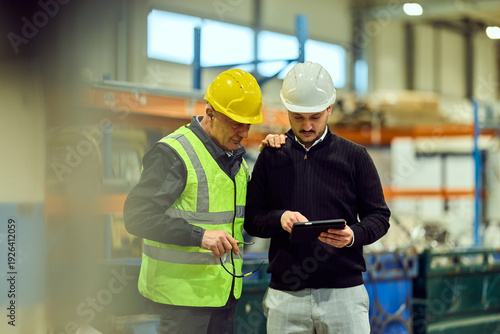 Factory Workers Inspecting Production Using Tablet — Teamwork and Safety on the Shop Floor