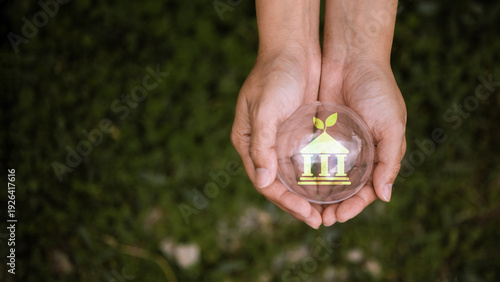 Obraz na plátně Sustainable Governance Concept with Green Institution Icon in Protective Hands