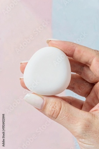 Hand holding porcelain pebble skin diagnostic sensor