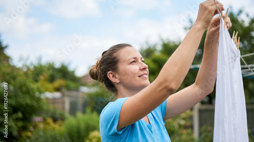 Wallpaper Mural Smiling woman hanging white laundry on clothesline in garden. Happy female doing domestic housework outdoors on sunny day. Freshness concept Torontodigital.ca