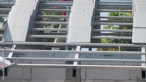 Lightweight concrete blocks installed on steel roof frame at residential construction site. Modern building system, structural engineering and housing development concept.