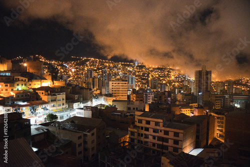 Night cityscape of La Paz, Bolivia with illuminated hills and cloudy sky