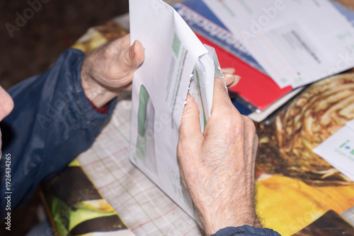 Foto Elderly man opening an electricity bill from the Spanish energy company Iberdrola
