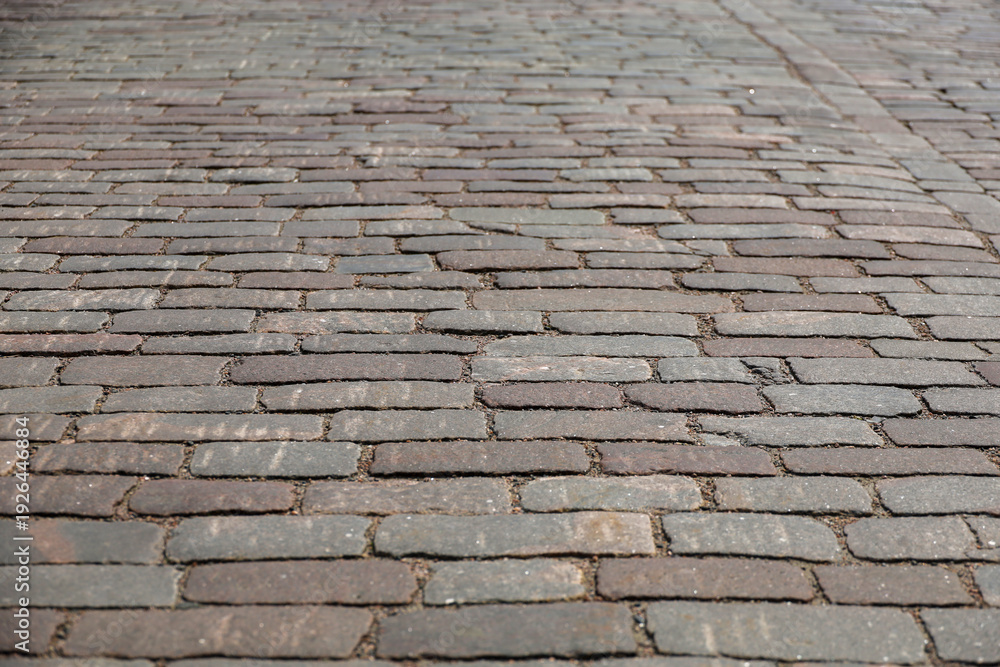 Naklejka premium A classic cobblestone or stone paving stone. This pavement is used on a medieval historic street or pedestrian area in the old town