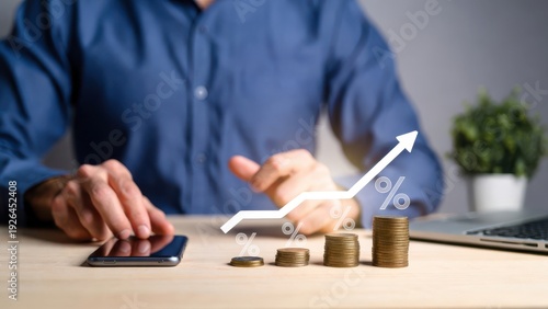 Person planning financial investments with coins and a growing graph on mobile device.