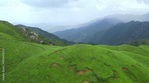 Drone flying forward above rolling green peaks in Wugong Mountain