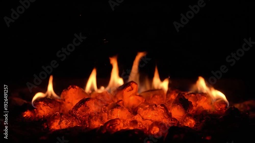 Burning firepit with wooden logs isolated on chroma key black background.