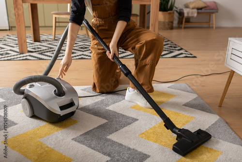 young woman cleaning her modern apartment while wearing casual clothes
