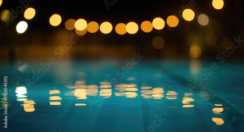 Blurred bokeh highlights on summer pool reflecting night lights with copyspace area