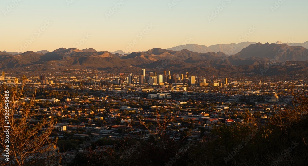 Fototapeta premium Metropolitan area glowing with afternoon sun and majestic hills behind