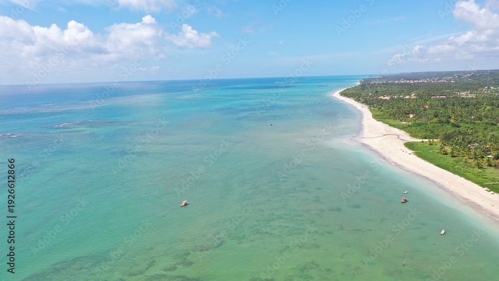 Fototapeta premium Wonderful view of white sand beach with turquoise waters and coral reefs in Milagres route near Maceio city, Alagoas State, Brazil 