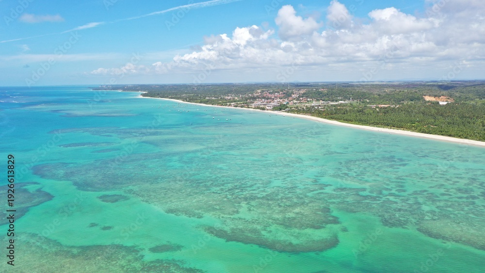 Obraz premium Wonderful view of white sand beach with turquoise waters and coral reefs in Milagres route near Maceio city, Alagoas State, Brazil