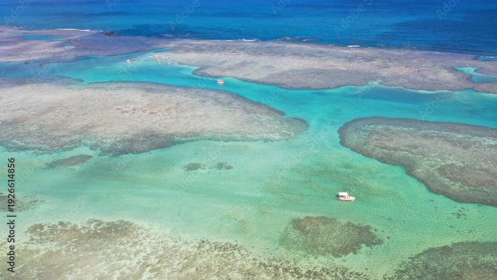 Obraz premium Wonderful view of white sand beach with turquoise waters and coral reefs in Milagres route near Maceio city, Alagoas State, Brazil