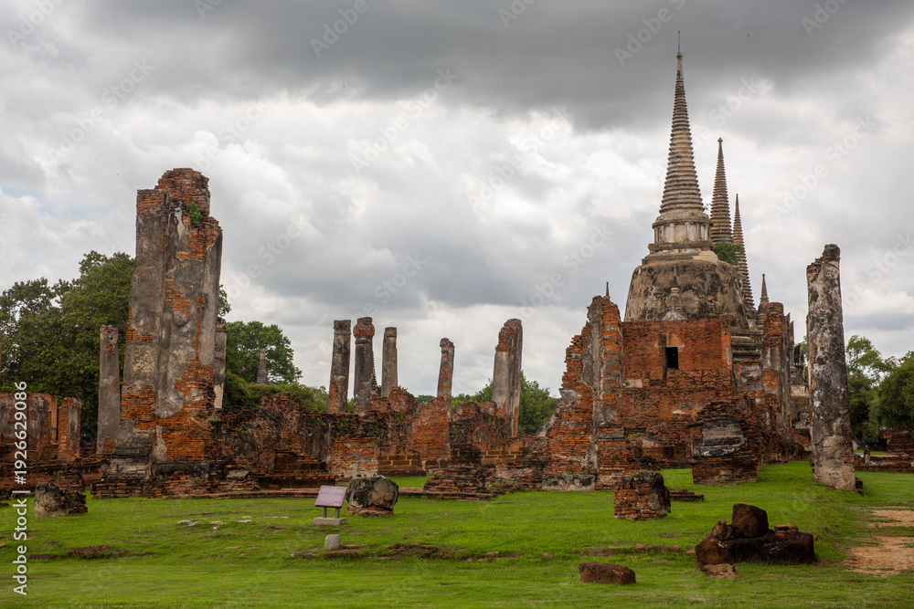 Obraz premium Panorama of the ancient ruins of Wat Phra Si Sanphet in Ayutthaya, Thailand. The composition emphasizes the scale of the former royal temple and the historic nature of the archaeological site.