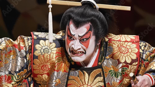 Kabuki Performer With White Red Face Paint And Intricate Gold Robe On Stage