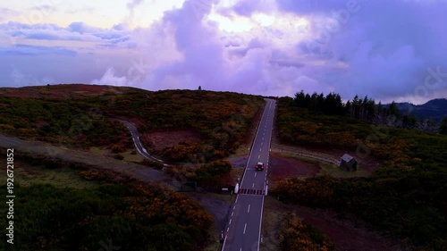 Red Car Driving on Scenic Mountain Road at Sunset