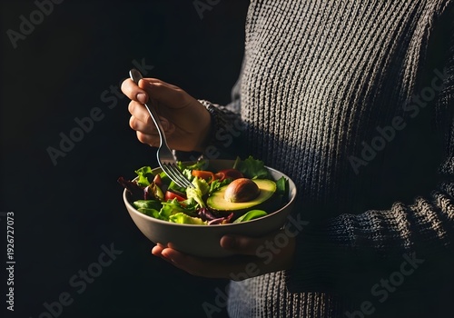 Person holding a fresh healthy salad bowl with avocado