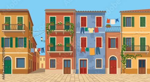 Colorful old European style buildings on a cobblestone street with balconies, flowers, and laundry hanging to dry under a clear blue sky on a sunny summer day